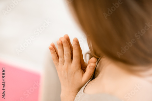 Girl does yoga. Young woman practices asanas on a beige one-ton background.