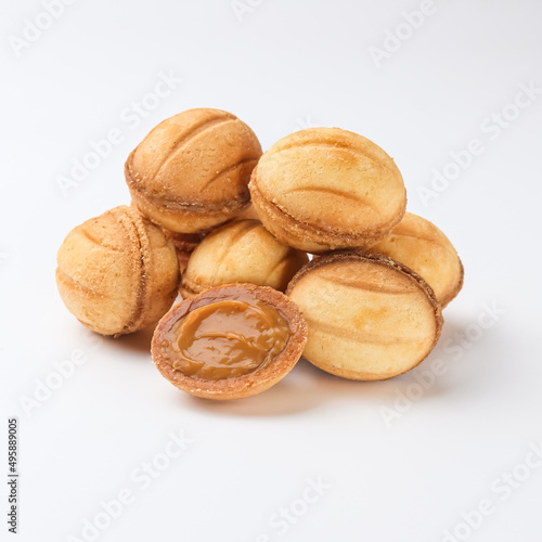 walnut shaped cookies with condensed milk on white background 