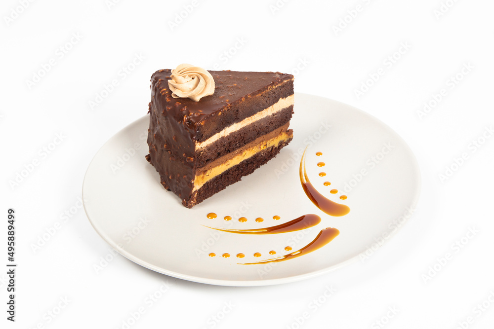 chocolate cake on plate with caramel sauce, white background chocolate cake on plate with caramel sauce, white background