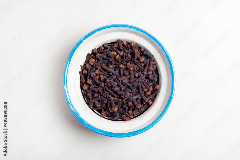 Spice cloves In a blue traditional ceramic plate, on white background top view
Spice cloves In a blue traditional ceramic plate, on white background top view