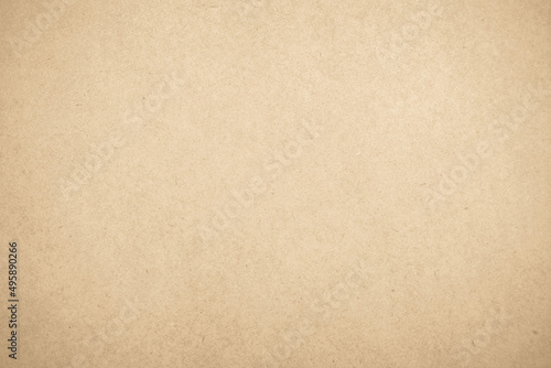 Brown recycled craft paper texture as background. Cream cardboard texture vintage page grunge vignette.