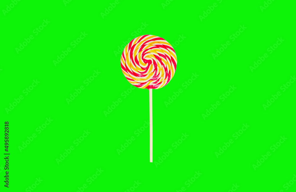 Close up colorful lollipop caramel on stick on green background Close up colorful lollipop caramel on stick on green background