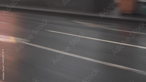 Gray, wet, shiny asphalt road, avenue, highway with white markings. Center metropolis reflections lanterns, buildings, stops. Businessman driving business meeting long-tail car. City life, bustle