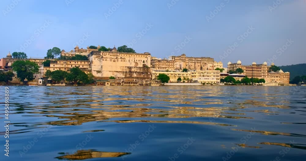 Udaipur City Palace view from lake Pichola. Luxury white palace as an example of Rajput architecture of Mewar dynasty rulers of Rajasthan is famous tourist Indian landmark. Incredible India heritage. Udaipur City Palace view from lake Pichola. Luxury white palace as an example of Rajput architecture of Mewar dynasty rulers of Rajasthan is famous tourist Indian landmark. Incredible India heritage.
