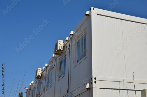 modular housing in stacked container cells. each module has a different function. part is a stair toilet, office kitchen and air conditioning on the wall. connected power cables in the socket