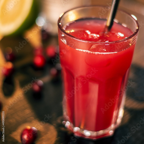 fresh red dink with staw, pomegranade seeds, limone on wooden table