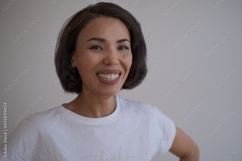 Close up portrait of a brunette asian smiling woman with hairstyling and make up, wearing t shirt Close up portrait of a brunette asian smiling woman with hairstyling and make up, wearing t shirt