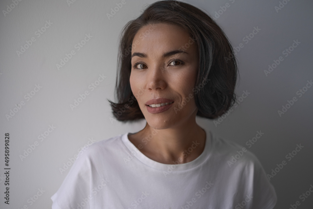 Close up portrait of a brunette asian smiling woman with hairstyling and make up, wearing t shirt Close up portrait of a brunette asian smiling woman with hairstyling and make up, wearing t shirt