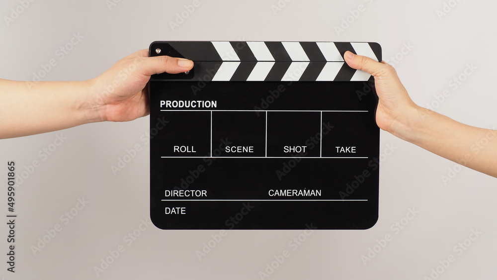 Two hands send and hold Black clapper board or movie slate on white background.