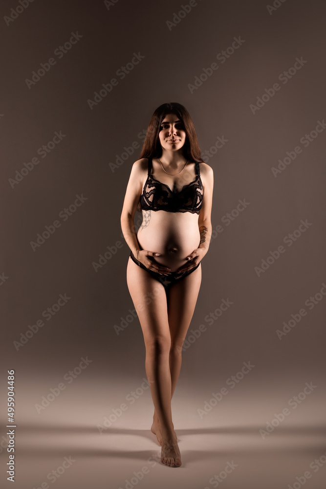 Pregnant woman in lingerie hugs her belly with her hands Pregnant woman in lingerie hugs her belly with her hands