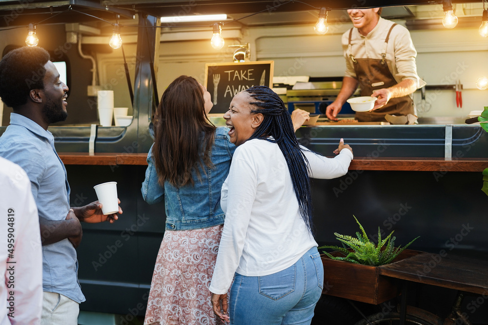 Multiracial people ordering gourmet food in front of food truck outdoor - Focus on african woman face