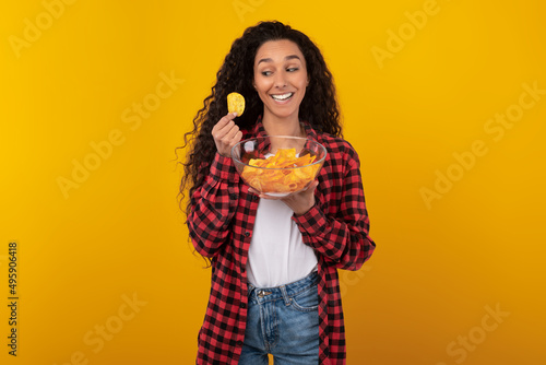 Excited Latin Lady Eating Delicious Potato Crisps