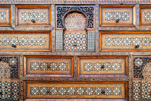 Beautiful antique inlaid wood cabinet with many drawers and compartments. Geometric arabesque patterns. photo