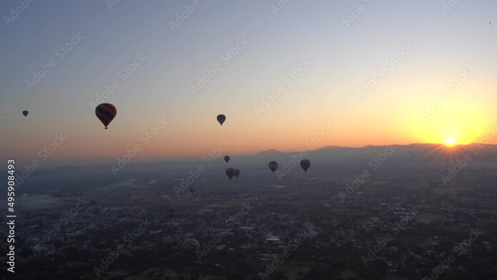 A beautiful sunrise from the hot air balloon up in the sky surrounded by other balloons in Teotihuacan A beautiful sunrise from the hot air balloon up in the sky surrounded by other balloons in Teotihuacan