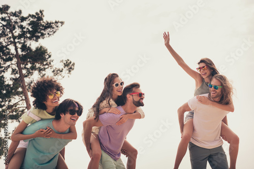 Photo of childish sweet young six friends wear casual clothes holding arms piggyback walking outside countryside
