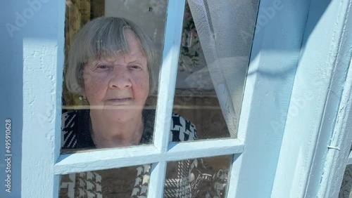 An elderly woman stands on the porch of a rural house in Ternopil region, Ukraine