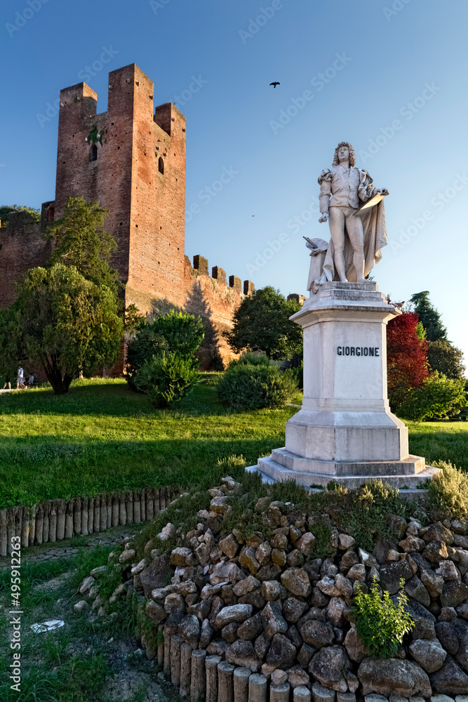 The statue of the painter Giorgione at the medieval walls of Castelfranco Veneto. Treviso province, Veneto, Italy, Europe.