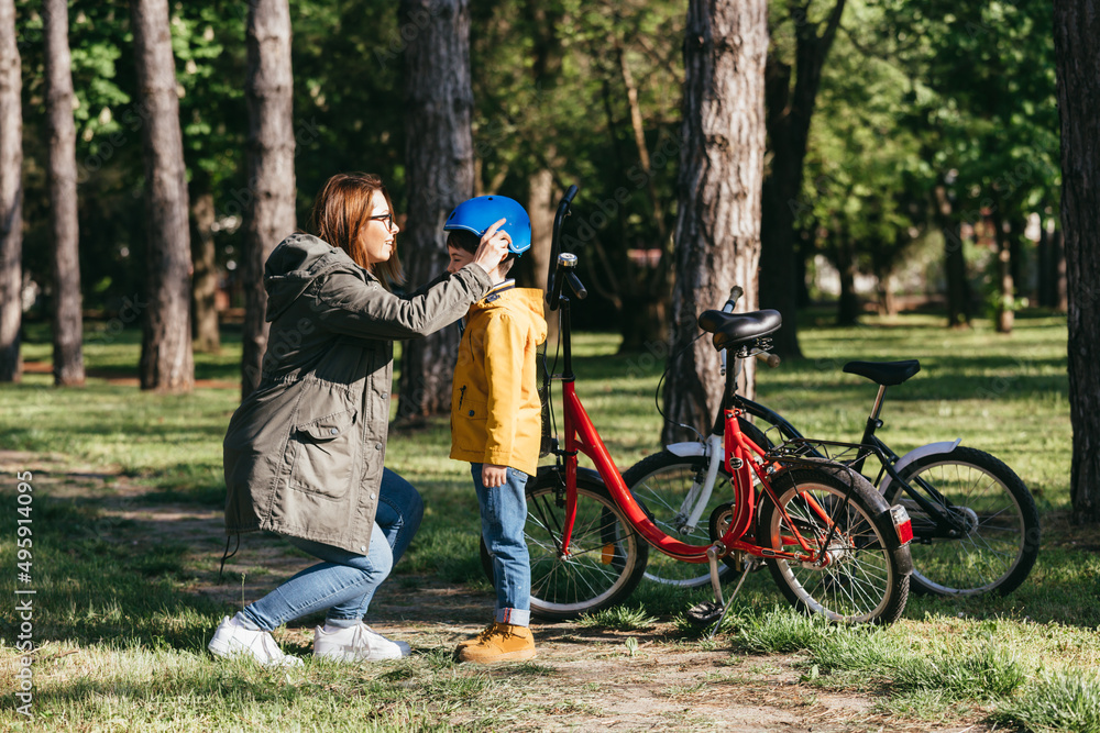 mother and son are riding bicycles in public park mother and son are riding bicycles in public park