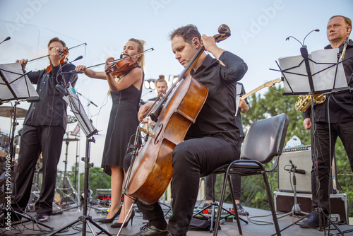 Valokuvatapetti Musical ensemble playing classical music on outdoor stage