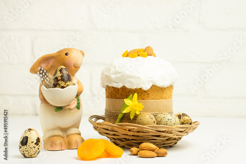 Easter bunny and Eastr cake   decorated with almonds  and candird fruits  on white background  with copy space . Happy Easter Holidays concept. photo