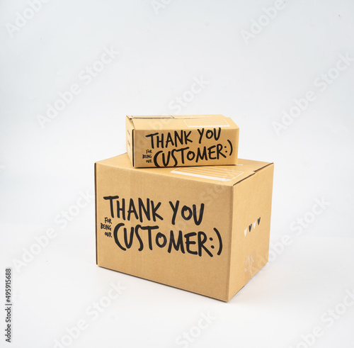 Two closed cardboard boxes taped up, and there is a Thank you for being our customer beside the parcel box for delivery and shopping online concept design isolated on white background.