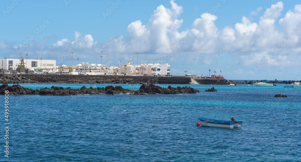 Vista panorámica del pueblo Punta Mujeres en Lanzarote con sus tradicionales casas blancas, frente a un mar turquesa y cristalino un día soleado de verano en las Islas Canarias.