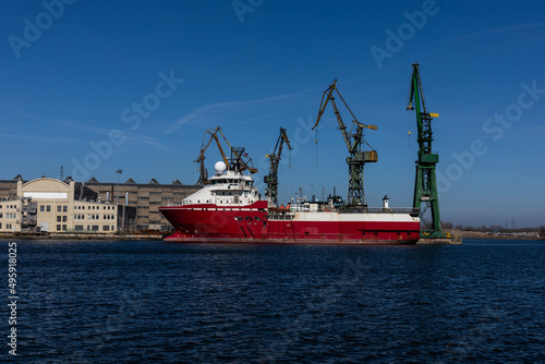 Red ship with port cranes in the background 