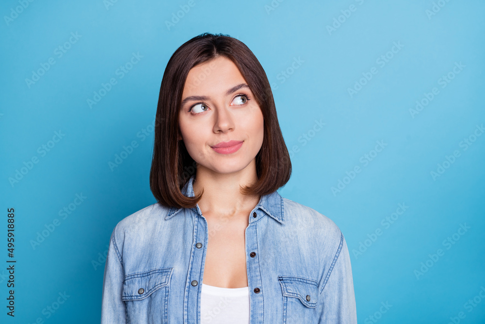Portrait of pretty minded person look interested empty space isolated on blue color background Portrait of pretty minded person look interested empty space isolated on blue color background
