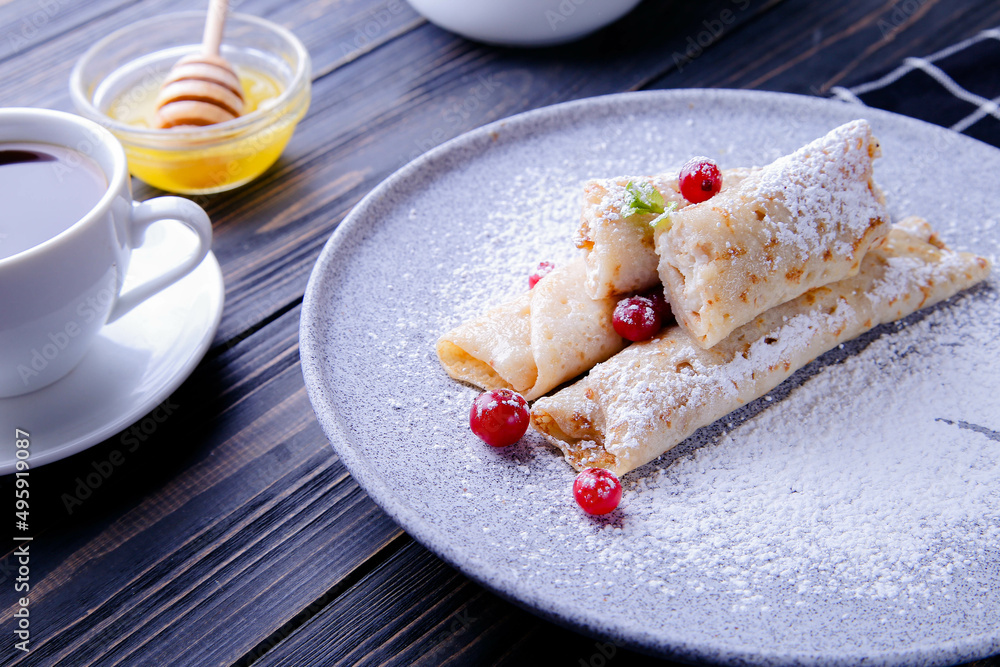 Pancakes with cottage cheese, cranberries and honey on a gray plate