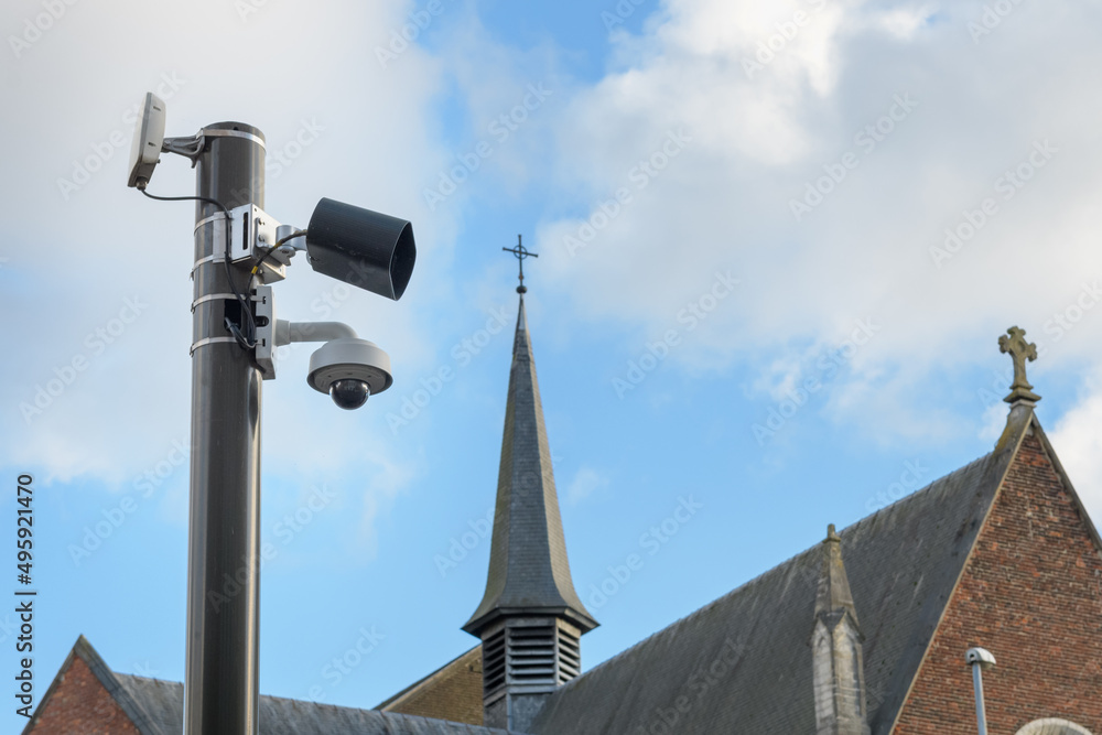 Security Camera or surveillance operating on a city street against the background of an old church in the city