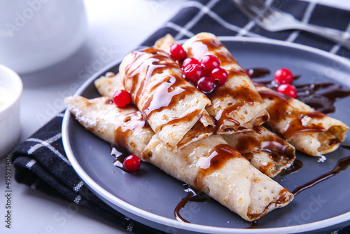 Pancakes with cottage cheese and cranberries covered with chocolate topping