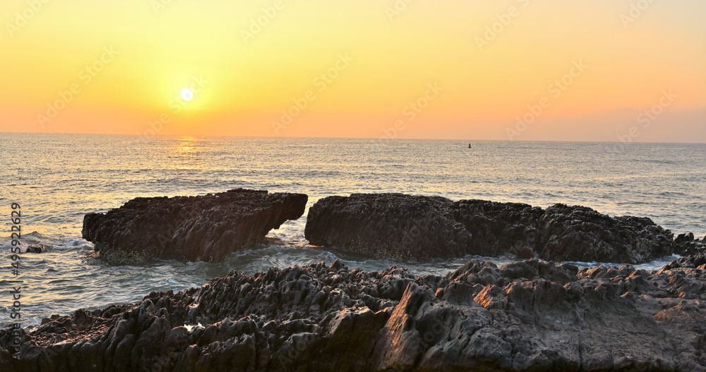 similar look sea rocks facing each illuminated by the rising sun