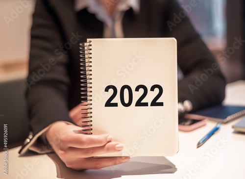 Businesswoman holds the notepad with the text 2022 year