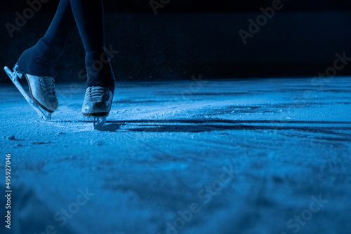 Foto Legs of an athlete skater performing elements of a single female choreography on ice stadium