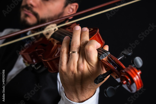 Hombre de vestimenta elegante tocando el violín photo