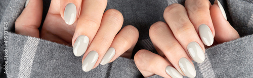 Beautiful womans hand with manicure in checkered shirt