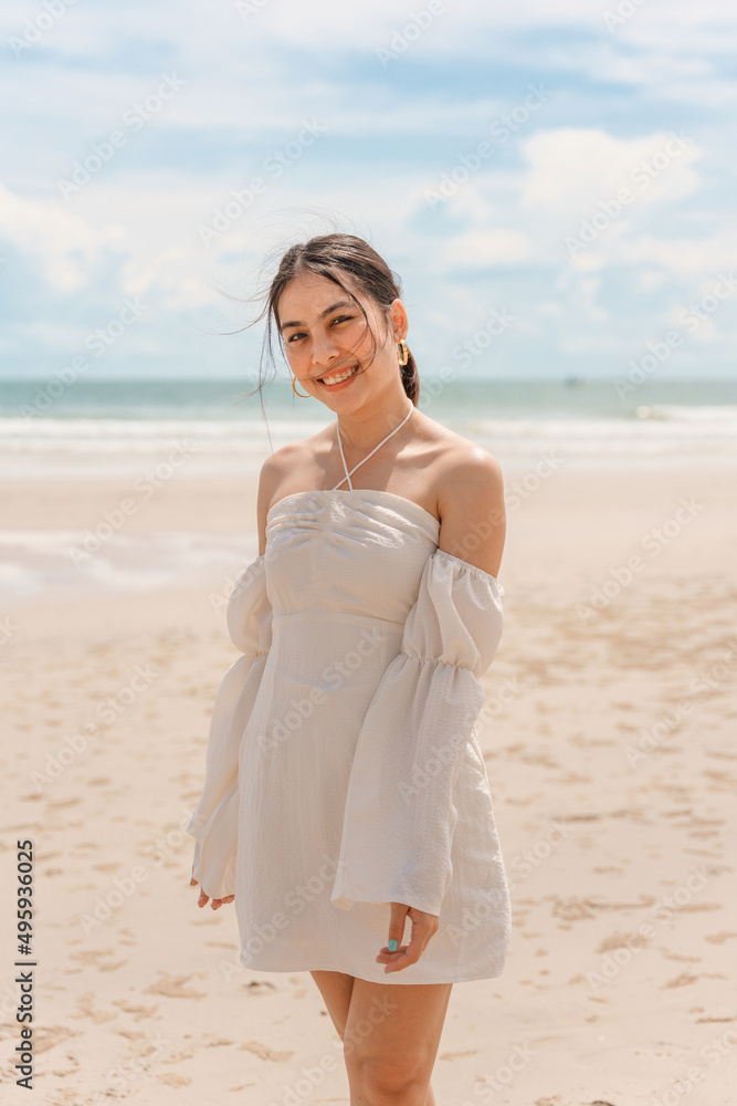 Young asian woman in dress enjoying on the beach in summer vacation Young asian woman in dress enjoying on the beach in summer vacation