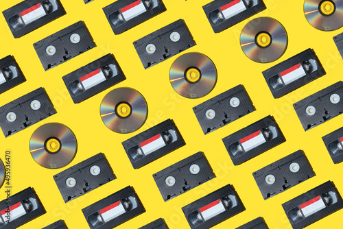 pattern with a VHS video cassette, Golden compact disc, Outdated technology background.