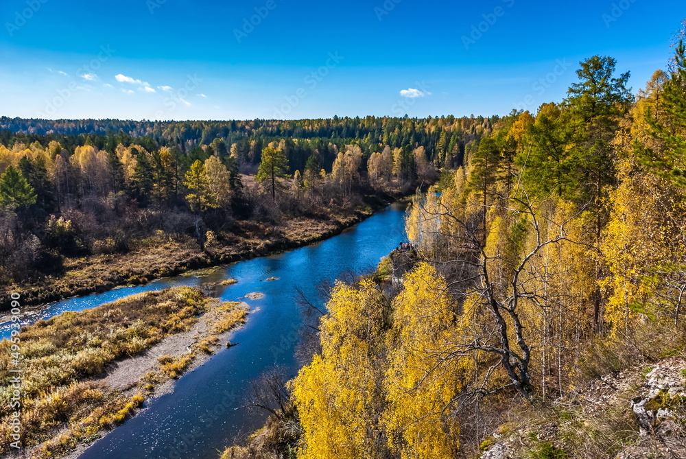 Autumn landscape with river, trees, grass and blue sky