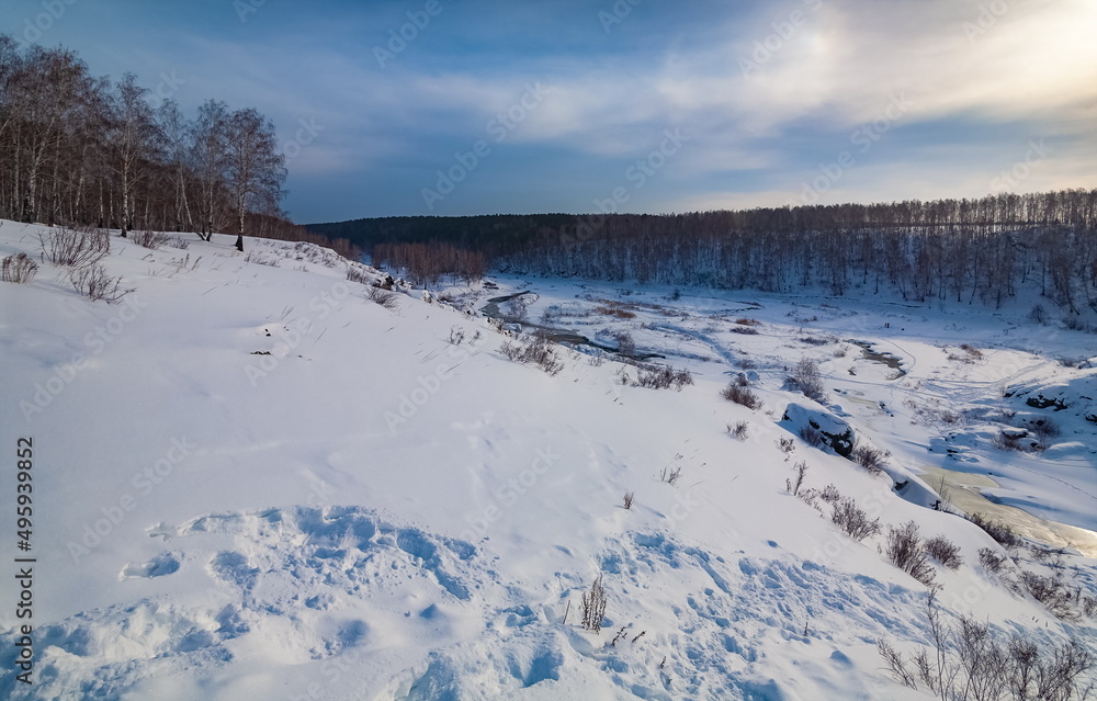 Winter landscape with trees and sky from the high rocky river bank Winter landscape with trees and sky from the high rocky river bank