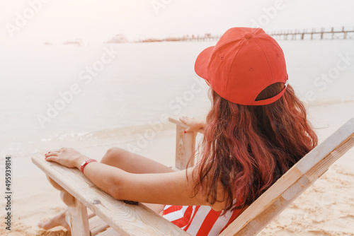 Photographie A girl is sunbathing on a chaise longue in a resort town