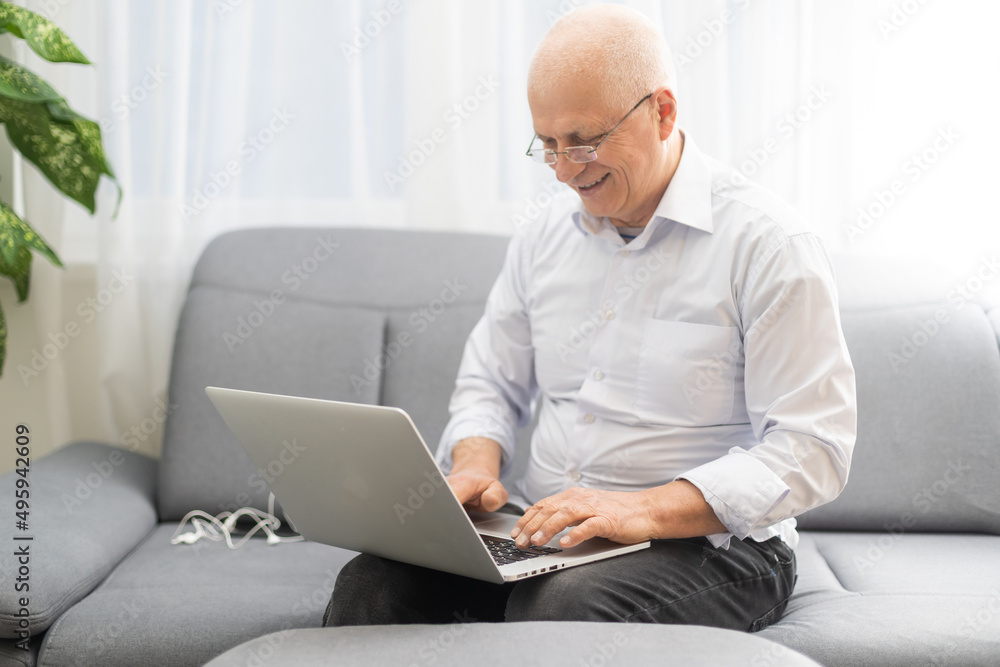 Senior man with eyeglasses connected on laptop at home Senior man with eyeglasses connected on laptop at home
