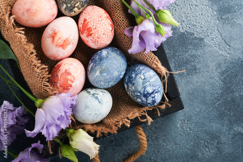 Easter eggs. Dyed Easter eggs with marble stone effect ref and blue color in rustic style on dark stone background. Easter background. Top view.