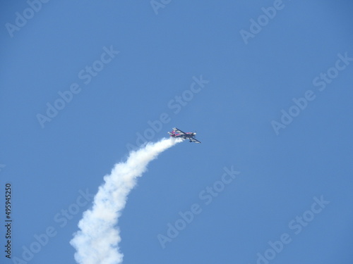 Airplane performing aerobatic stunts at an airshow in the skies of southern California.