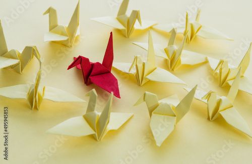 A red origami crane stands out