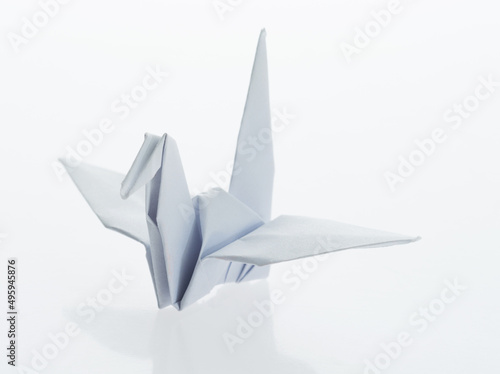 White origami paper crane on white background