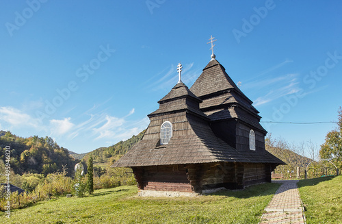 Church of the Archangel Michael Old wooden building in mountains. wonderful sunny autumn weather. trees in fall foliage. cloudless sky. Uzhok, Ukraine