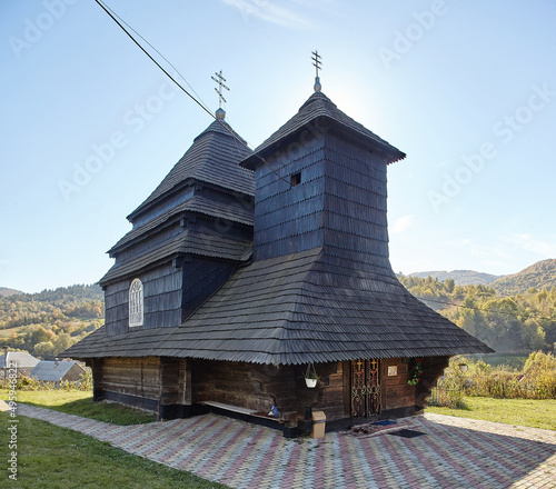 Church of the Archangel Michael Old wooden building in mountains. wonderful sunny autumn weather. trees in fall foliage. cloudless sky. Uzhok, Ukraine photo