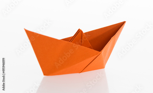 Orange origami boat on white background