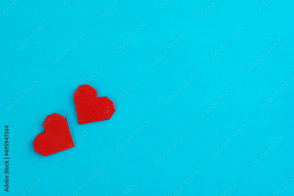 Fototapeta premium Red origami hearts on blue background